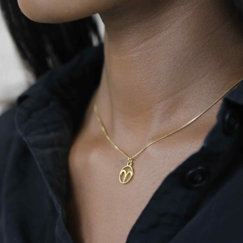 Model Wearing Charming Zodiac Aries Minimalist Solid Gold Pendant By Jewelry Lane