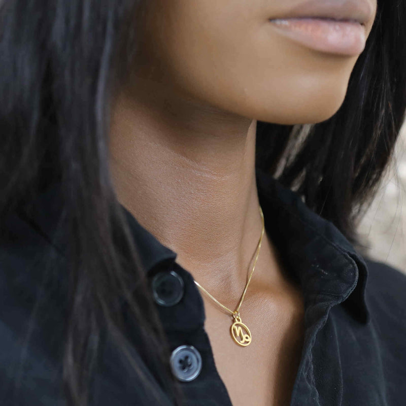 Model Wearing Charming Zodiac Capricorn Minimalist Solid Gold Pendant By Jewelry Lane