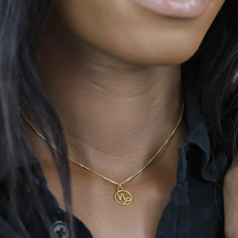 Model Wearing Charming Zodiac Capricorn Minimalist Solid Gold Pendant By Jewelry Lane