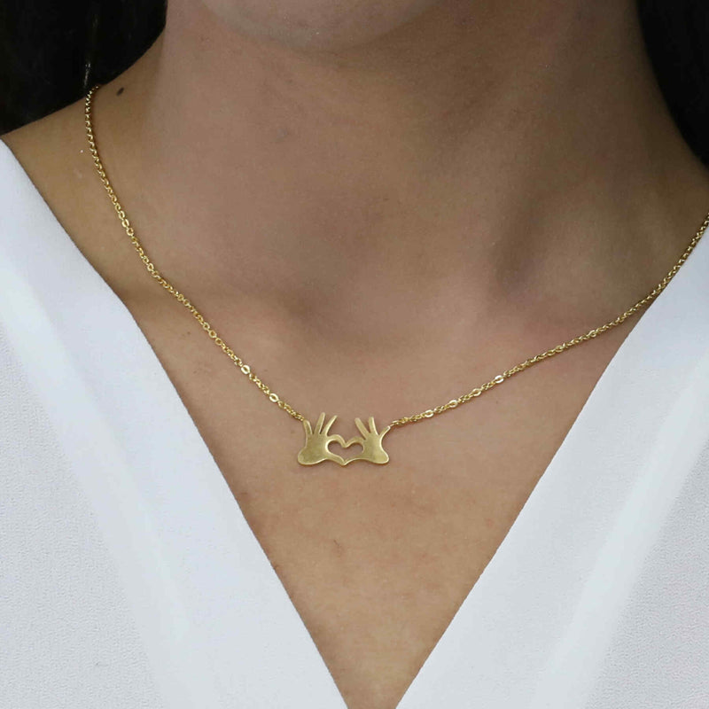 Model Wearing Beautiful Modern Heart In Hand Solid Gold Necklace By Jewelry Lane