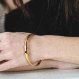 Model Wearing Beautiful Timeless Polished Solid Gold Bangle by Jewelry Lane